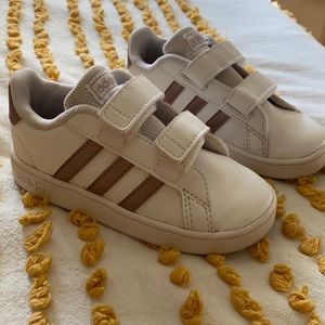 Adidas Grand Court white leather w matte gold accents. Velcro closure size 8T.